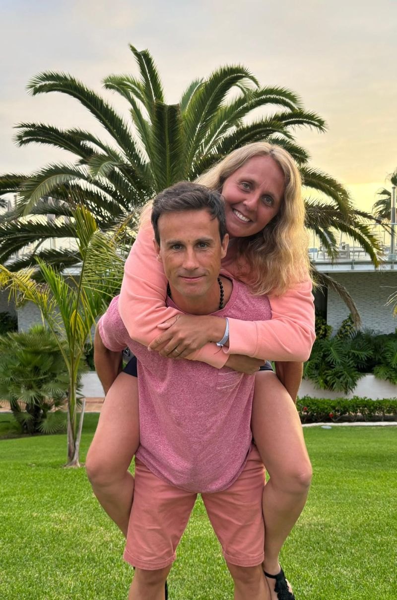 Sébastien Mot portant sa femme sur son dos devant un palmier
